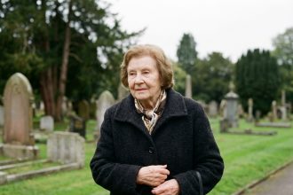 Femme âgée en vêtement sombre dans un cimetière paisible
