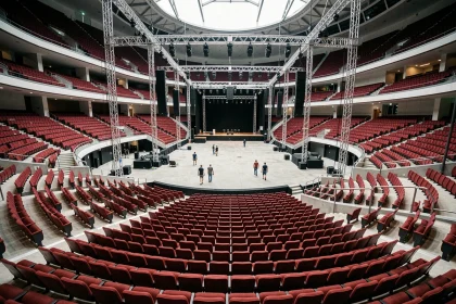 Vue panoramique de l'intérieur de la salle Bercy depuis les gradins supérieurs avec rangées de sièges rouges et scène centrale